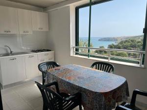a kitchen with a table and chairs and a window at Residence Nido Verde in Peschici