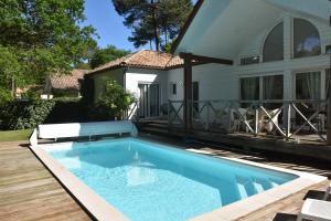 a swimming pool in front of a house at Louise-Angèle in Biscarrosse