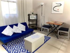 a living room with a blue couch and a table at Apartamentos Sacor #1 Studio in Curridabat