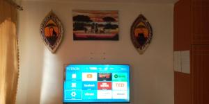 um ecrã de televisão numa parede com dois espelhos em The Buckingham Palace Nahashon Kimemia Studio em Nairobi