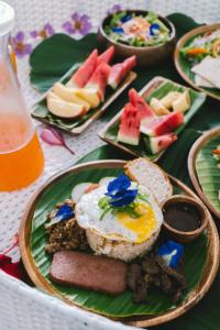 a plate of food with eggs and fruit on a table at Bahala Na Villas in El Nido