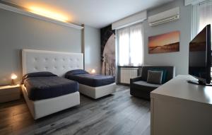 1 dormitorio con 2 camas, sofá y silla en Holiday Homes Aparthotel Milano, en Milán