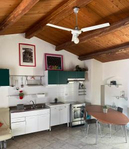 una cucina con armadi bianchi e soffitto in legno di Pikaret Bed&Breakfast a Corato