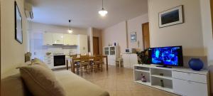 a living room with a couch and a tv and a kitchen at Nonna Eleonora in Otranto