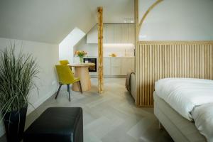 a bedroom with a bed and a table and a kitchen at Güldenstubbe Residences in Kuressaare