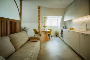 Una sala de estar con un sofá y una cocina. en Güldenstubbe Residences, en Kuressaare