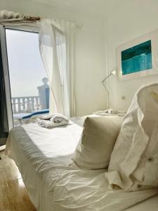 Cama blanca en habitación con ventana en Molino Azul 3A, Wohnung mit Meerblick, en Valle Gran Rey