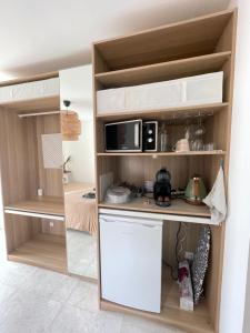 una pequeña cocina en una pequeña habitación con microondas en Ty kaz : élégant, tout confort et bien situé en Névez