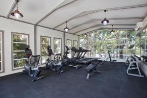 a gym with several treadmills and elliptical machines at Health Land Resort & Spa in Pattaya South