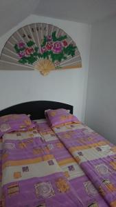 Una cama con un edredón morado encima. en Casa Crăiesei, en Ocna Şugatag