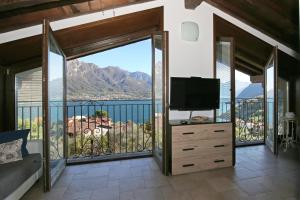 um quarto com uma ampla varanda e uma televisão em ALBA e TRAMONTO Appartamenti vista lago em Bellagio