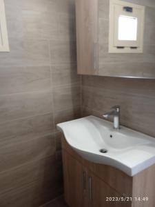 a bathroom with a white sink and a mirror at Evoikos beach & resort in Livanátai