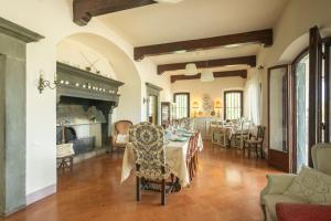 uma sala de jantar com uma mesa e uma lareira em Liberty Villa with private garden and pool by VacaVilla em Turignano