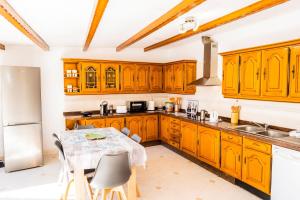 a kitchen with wooden cabinets and a table with chairs at Live Caletillas Taunus in Candelaria