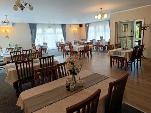 jadalnia ze stołami i krzesłami w restauracji w obiekcie Hotel Wanda w mieście Kętrzyn