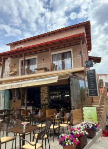 a restaurant with tables and chairs in front of a building at AGORA LUXURY LOFT in Ayios Nikolaos Sithonia