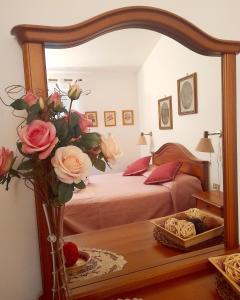 a bedroom with a bed and a vase of flowers in a mirror at La Nuova Paranza - Le Grazie - Portovenere - Cinque Terre in Portovenere