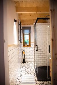 a bathroom with a white tiled shower with a window at Dom Majówka i Apartamenty Bartoszówka i Michałówka in Karwieńskie Błoto Drugie +66 photos