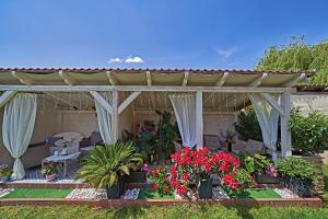 uma pérgola com flores e plantas num quintal em Vintiamo Apartmanok em Egerszalók