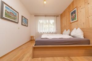 1 dormitorio con 1 cama con cabecero de madera en Ladurner Home, en Brunico