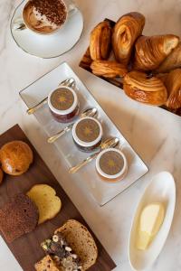einen Tisch mit Platten aus Brot und Gebäck in der Unterkunft Bulgari Hotel Paris in Paris