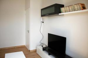sala de estar con TV de pantalla plana en la pared en Casa sobre o mar A Ceboleira, en Raxó