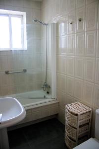 een badkamer met een douche, een bad en een wastafel bij Casa sobre o mar A Ceboleira in Raxo