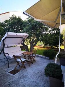 a table and a chair under an umbrella at Apartment Maria in Zadar