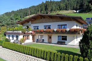 a house in the mountains with a hedge at Appartement Schneeberger in Westendorf