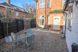 a patio with a table and chairs in a yard at Woodhall Spa - stylish, central flat in Lincolnshire