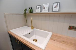 a bathroom sink with a faucet on a counter at Woodhall Spa - stylish, central flat in Lincolnshire