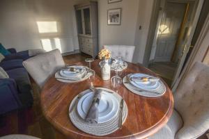 a wooden table with plates and napkins on it at Woodhall Spa - stylish, central flat in Lincolnshire