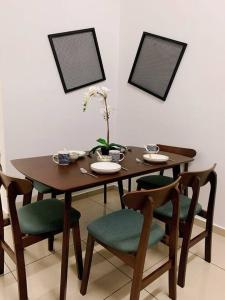 a dining room table with chairs and a table with ahibition at SSR Stay n rest 887芙蓉休闲站民宿 in Seremban