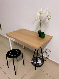 a wooden table with a vase of flowers on it at SSR Stay n rest 887芙蓉休闲站民宿 in Seremban