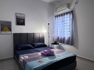 a bedroom with a bed with a purple blanket on it at SSR Stay n rest 887芙蓉休闲站民宿 in Seremban