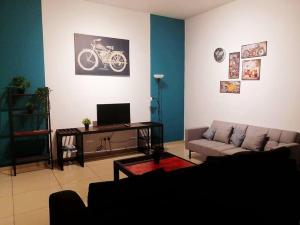 a living room with a couch and a tv at SSR Stay n rest 887芙蓉休闲站民宿 in Seremban