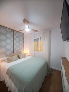 1 dormitorio con 1 cama y ventilador de techo en Jardin del Mar, en La Manga del Mar Menor