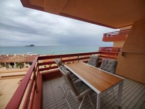 een balkon met een tafel en stoelen en de oceaan bij Jardin del Mar in La Manga del Mar Menor