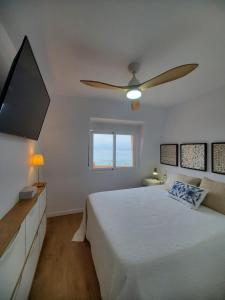 een slaapkamer met een bed en een plafondventilator bij Jardin del Mar in La Manga del Mar Menor