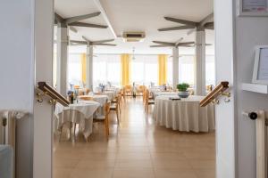ein Esszimmer mit weißen Tischen und Stühlen in der Unterkunft Hotel Doria in Cavi di Lavagna + 85 Fotos