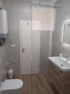 a white bathroom with a toilet and a sink at House Petar by sea in Trogir +24 photos