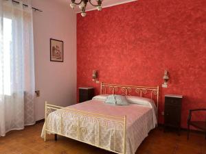 1 dormitorio con 1 cama con pared roja en Dimora Falconi, en Arnesano