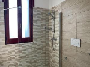 baño con ducha y puerta de cristal en Dimora Falconi, en Arnesano
