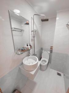 a bathroom with a toilet and a sink and a mirror at The Moment - Quang Anh Hotel Vũng tàu in Vung Tau