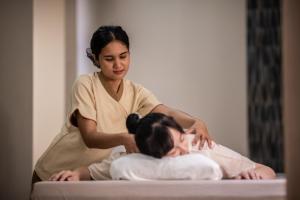 a woman sitting on a bed with a patient at Areca Resort and Spa - SHA Extra Plus in Kathu