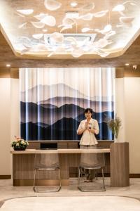 a man standing at a desk in a lobby at Areca Resort and Spa - SHA Extra Plus in Kathu