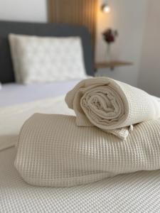 Una toalla enrollada encima de una cama en Lili Rose Mandre Luxury Apartments en Mandre