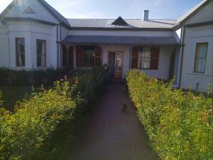 a white house with a pathway in front of it at Ramble Guest House in Riversdale