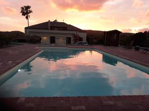 a swimming pool in front of a house at Pessighette Dimora Di Campagna in Bosa