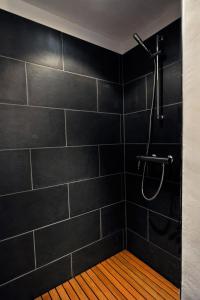 a black bathroom with a shower with a wooden floor at Villa La Laguna in Lajares